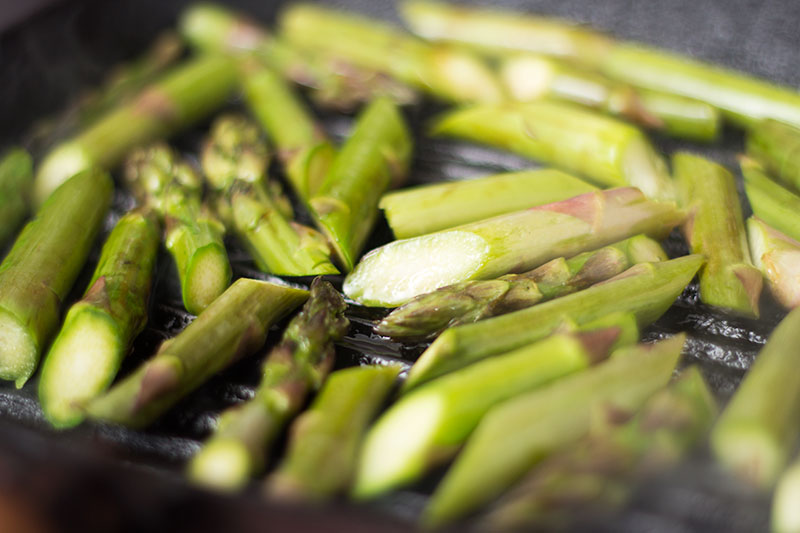 Asparagus cooking on a griddle
