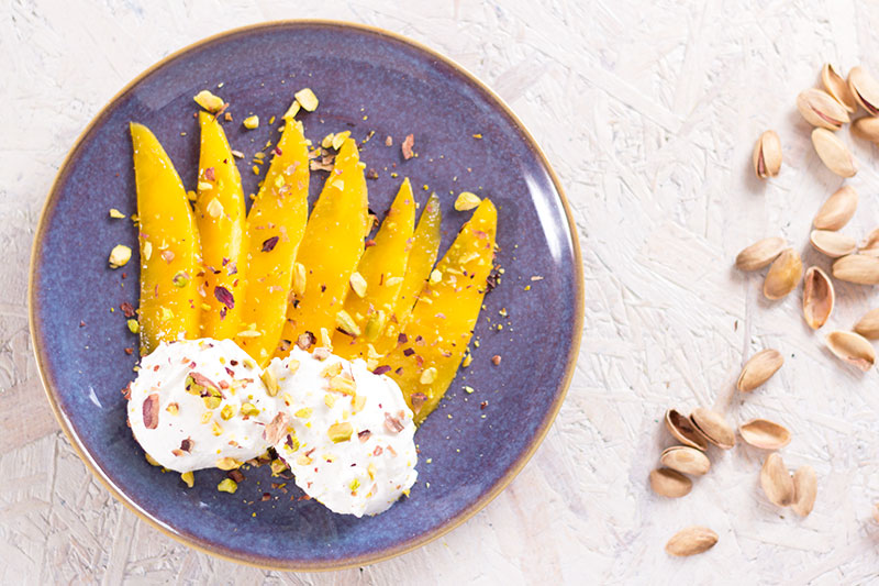 Mango, labneh and pistachio on a plate
