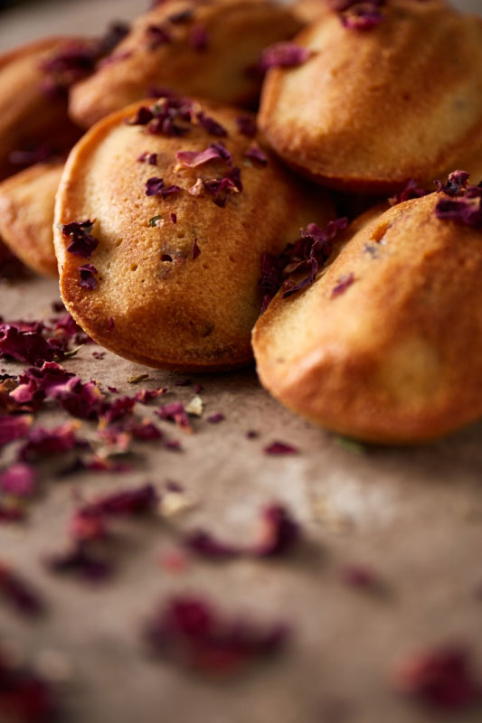 Whimsical spelt madeleines flavoured with fragrant rosewater and decorated with delicate edible rose petals are a delicious afternoon tea time treat as well as being made with no refined sugar, so feature high up on the healthy bake stakes!
