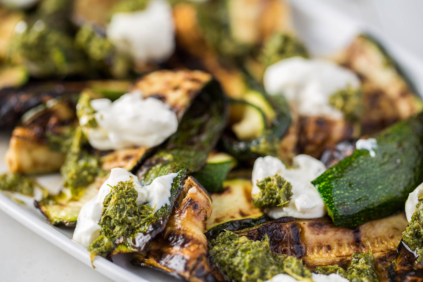 A bright and full flavoured summery vegetarian BBQ Courgette dish which uses full flavoured charred courgette slices topped with thick, creamy labneh and rich, tangy mint sauce. It's a dish to have both vegetarians and meat eaters drooling!
