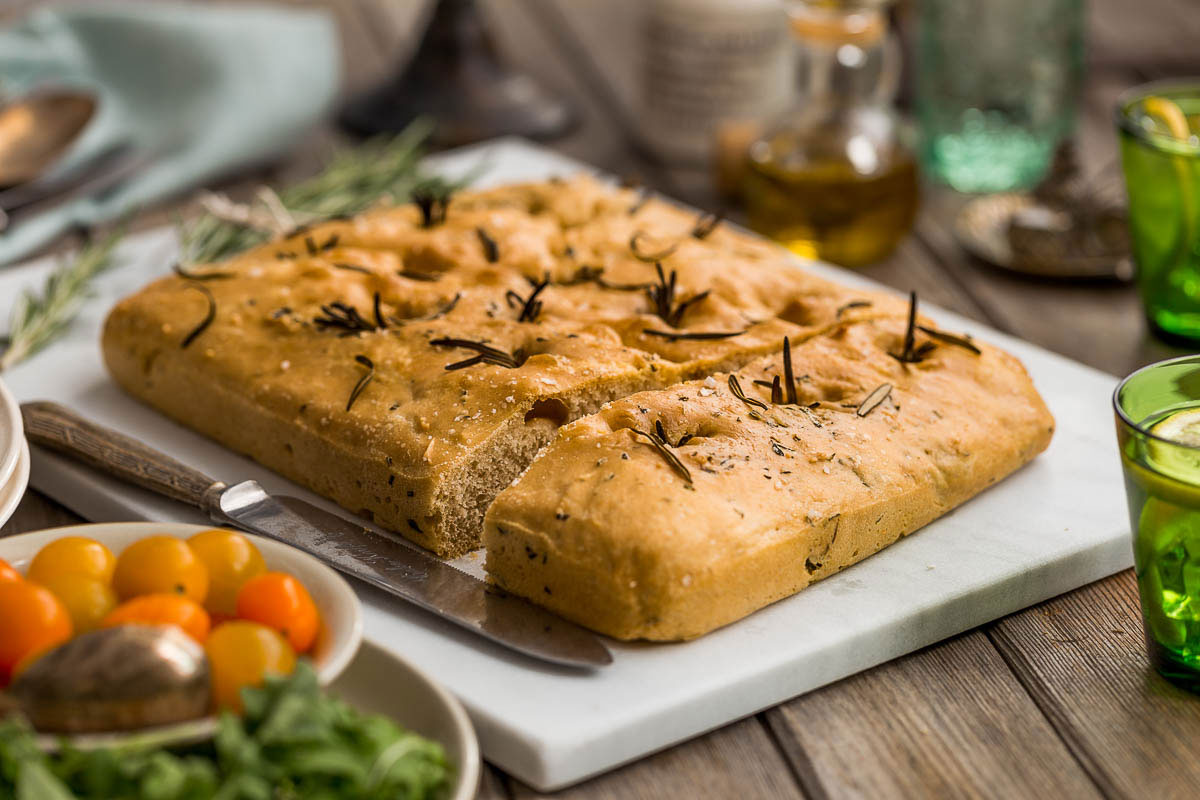 Tender, fresh, homemade Italian spelt focaccia, studded with rosemary sprigs and drizzled with olive oil. The job of baking bread at home may seem like an onerous task, but when it produces such beautifully tender, flavoursome bread, the ability to bake your own bread begins to feel more like a special privilege.